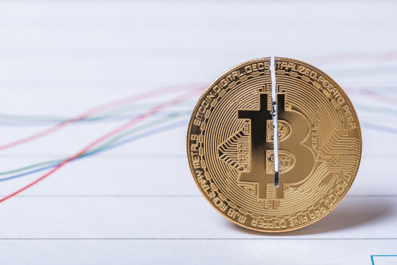 Bitcoin halvering, mynt delt i to med en graf i bakgrunnen